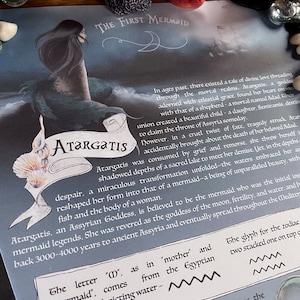 May include: A close-up of a text-based image with a blue and white illustration of a mermaid. The text reads "The First Mermaid" and "Atargatis". The text also describes the mermaid as the "Assyrian Goddess" and the "initial inspiration for mermaid legends".