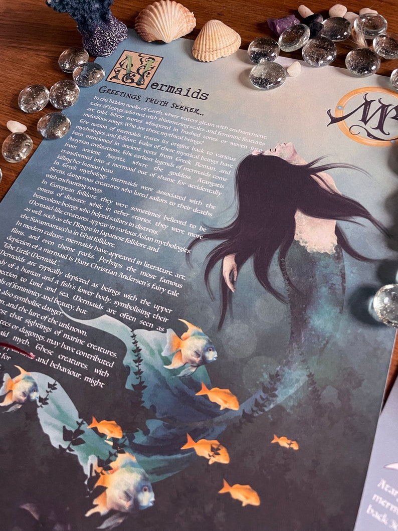 May include: A blue and green illustration of a mermaid with long black hair and a tail. The mermaid is surrounded by a school of orange fish. The text "Mermaids Greetings, Truth Seeker..." is at the top of the image.