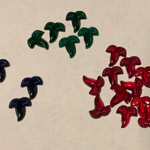 May include: Assortment of palm tree shaped glass embellishments in red, green, and blue.