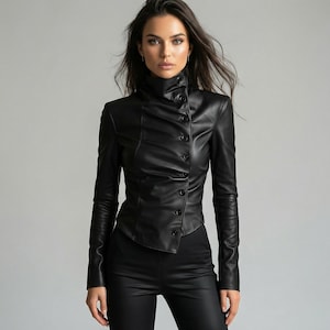May include: A black leather jacket with a high, buttoned collar and long sleeves. The jacket has a fitted silhouette and a series of buttons down the front. The model is wearing black leather pants. The background is a solid gray.