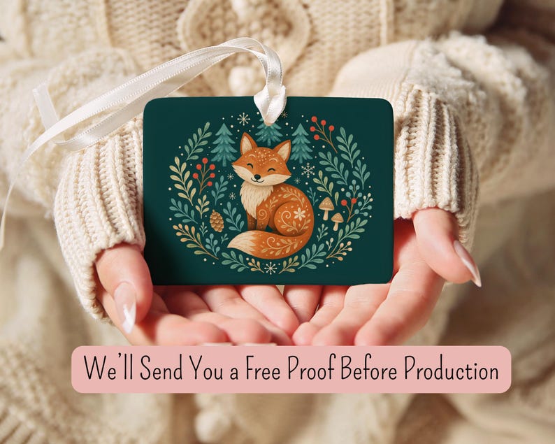 May include: A rectangular dark green ornament featuring a central illustration of a fox surrounded by pine trees, leaves, berries, and mushrooms. The ornament has a white ribbon loop at the top. The text reads: We'll Send You a Free Proof Before Production.