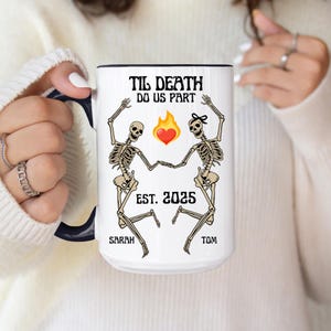May include: White ceramic mug with a black rim and handle. The mug features a design with two skeleton figures, a heart, and the text "Til Death Do Us Part" and "Est. 2025". Names "Sarah" and "Tom" are also included.