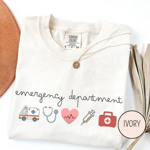 Emergency department shirt with medical icons including ambulance, stethoscope, heart and syringe in minimal style for ER nurse apparel