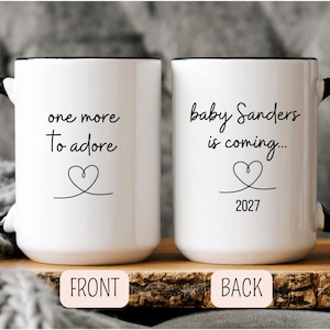 May include: A white ceramic mug with a black handle and the text "But First, Coffee" in a bold, black font. The mug is set against a neutral background, highlighting its simple design.