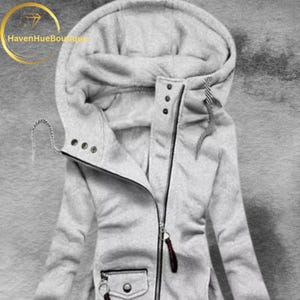 May include: A light gray hooded jacket with a full-length zipper and a small pocket. The jacket has a drawstring hood and a high collar. The zipper pull is a dark brown color. The jacket is made of a soft, textured material.