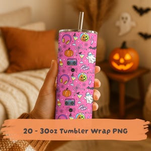 May include: A cylindrical stainless steel tumbler with a pink background featuring a repeating pattern of orange pumpkins, white ghosts with sunglasses, boomboxes, cocktails, headphones, bows, and flip-flops, topped with a metal straw.
