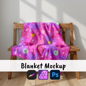 May include: A pink and purple blanket with a repeating pattern of butterflies, hearts, stars, headphones, and other retro-themed graphics. The blanket is draped over a wooden chair. The words "Blanket Mockup" are at the bottom.