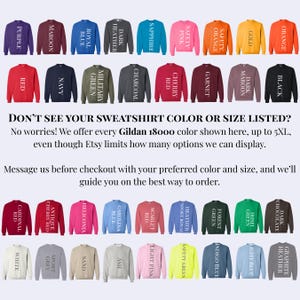 Puede incluir: Una variedad de sudaderas Gildan 18000 en varios colores, incluyendo morado, granate, azul real y negro. La imagen muestra una amplia gama de colores disponibles, con texto que indica tallas hasta 5XL.