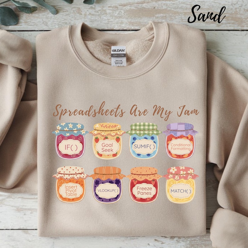 K&ouml;nnte beinhalten: Beigefarbenes Sweatshirt mit dem Text "Spreadsheets Are My Jam" und Illustrationen von Marmeladengl&auml;sern, die jeweils mit Tabellenkalkulationsfunktionen wie IF(), SUMIF() und VLOOKUP() beschriftet sind.