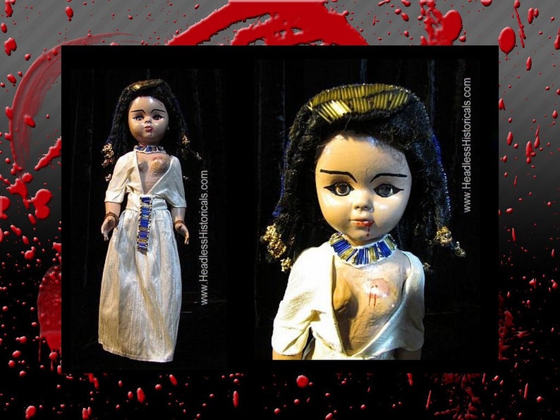 Puede incluir: Dos mu&ntilde;ecas vintage vestidas como faraones egipcios. Las mu&ntilde;ecas tienen cabello negro, ojos pintados y llevan vestidos de lino blanco con detalles dorados y azules. La mu&ntilde;eca de la derecha tiene una mancha roja en el pecho.