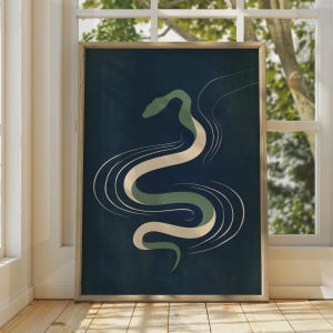 Könnte beinhalten: Ein gerahmter, rechteckiger Wandkunstdruck mit einer stilisierten, abstrakten Schlangenillustration. Die Schlange ist in gedeckten Salbeigrün- und Cremetönen gehalten, vor einem tief dunkelblauen Hintergrund mit feinen, weißen Linien.