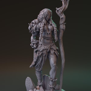 Puede incluir: Figura gris de una mujer guerrera, sosteniendo una calavera y un bastón. Lleva una falda de piel, armadura de hombro con calaveras y tiene el pelo largo trenzado. La figura está sobre una base rocosa.