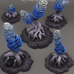 May include: Several fantasy-themed sculptures of alien plants. The plants have a blue and white layered structure, with a gray trunk and roots. They are set on a dark, textured base. The image is well-lit, showcasing the details of the models.