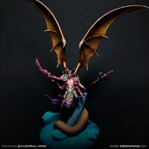 Puede incluir: Figura en miniatura de fantasía de un demonio con grandes alas marrones, cuerpo rojo rosado y múltiples brazos. El demonio sostiene una espada y un báculo. La figura está pintada con sombreado y resaltes detallados, y está posada sobre una base azul con una serpiente marrón.