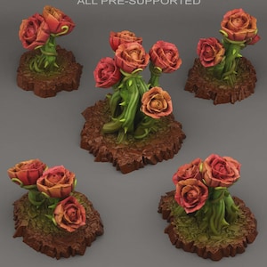 Può includere: Una collezione di sculture di rose in miniatura. Ogni rosa è una miscela di tonalità rosse e arancioni, su steli verdi con spine. Le basi sono marroni strutturate, che assomigliano alla terra. L'immagine è presa dall'alto.