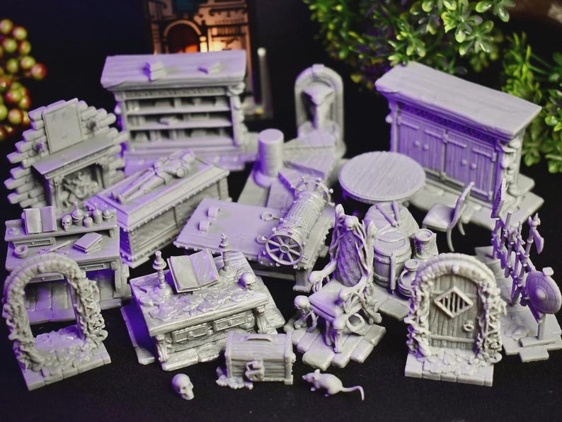 May include: A collection of gray miniature fantasy terrain pieces, including a table, chairs, a cabinet, a coffin, a desk, a chest, and an archway. The pieces are designed for tabletop gaming and role-playing games.