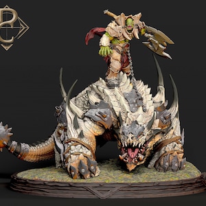 Puede incluir: Figura detallada de una criatura fantástica con un guerrero orco montado en su espalda. El orco tiene la piel verde y está blindado, empuñando un hacha grande. La criatura es una mezcla de rasgos reptilianos y mamíferos, con grandes cuernos y dientes. La paleta de colores incluye tonos de marrón, gris y beige.