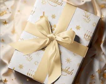 Puede incluir: Una caja de regalo rectangular envuelta en papel blanco con un patrón dorado de menorás, dreidels y copos de nieve con el texto Happy Hanukkah. Una cinta de satén dorada clara, ancha y lisa, está atada en un gran lazo central.