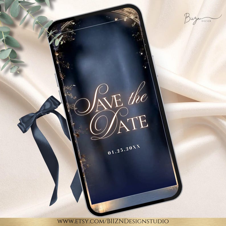 May include: A smartphone displays a digital invitation with the text "Save the Date" in elegant script. The background is a dark blue gradient with gold accents. A navy blue ribbon and greenery are in the foreground.
