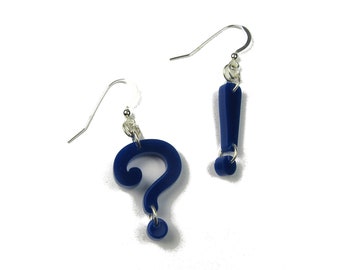 May include: A pair of blue earrings, one shaped like a question mark and the other shaped like an exclamation point.