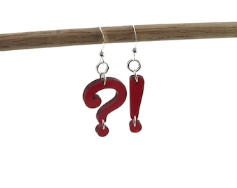 May include: Red acrylic earrings shaped like a question mark and an exclamation point.