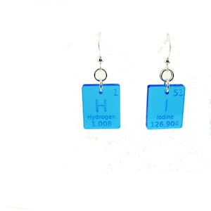 May include: A pair of blue earrings with silver hooks. Each earring features a square charm with the periodic table element symbol and name. The left earring has the symbol "H" for Hydrogen with the atomic number "1" and atomic weight "1.008". The right earring has the symbol "I" for Iodine with the atomic number "53" and atomic weight "126.904".