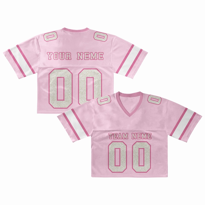 Puede incluir: Camiseta de f&uacute;tbol rosa con rayas blancas y rosas en las mangas. La camiseta tiene el texto "YOUR NEME" y "TEAM NEME" con el n&uacute;mero "00" en una fuente brillante. La camiseta tiene cuello en V.