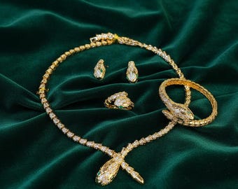 Conjunto de joyería con motivo de serpiente: collar, pulsera, pendientes y anillo ajustable de circonitas bañados en oro de 22 quilates.