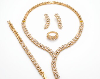 22-karaats vergulde sieradenset met bloemenmotief: ketting, armband, oorbellen en ring.
