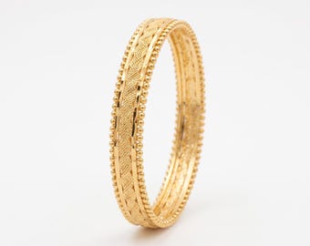 22-karaats vergulde armband met textuur en kralenrand.