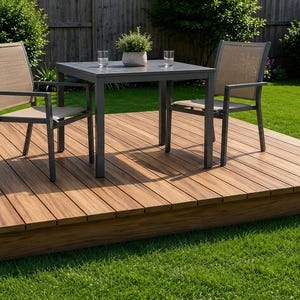 Peut inclure: Ensemble de patio extérieur sur une terrasse en bois. L'ensemble comprend une table carrée grise, deux chaises et une petite plante en pot. La terrasse est en bois brun clair et entourée d'herbe verte.