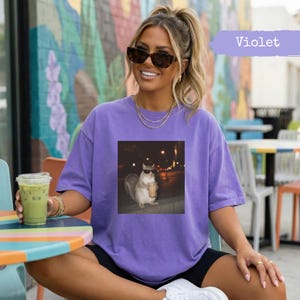 Purple t-shirt with squirrel wearing sunglasses and holding coffee.