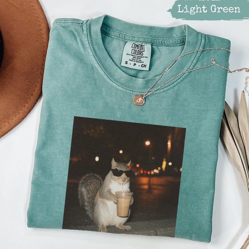 Green t-shirt with sunglasses-wearing squirrel holding a coffee cup.