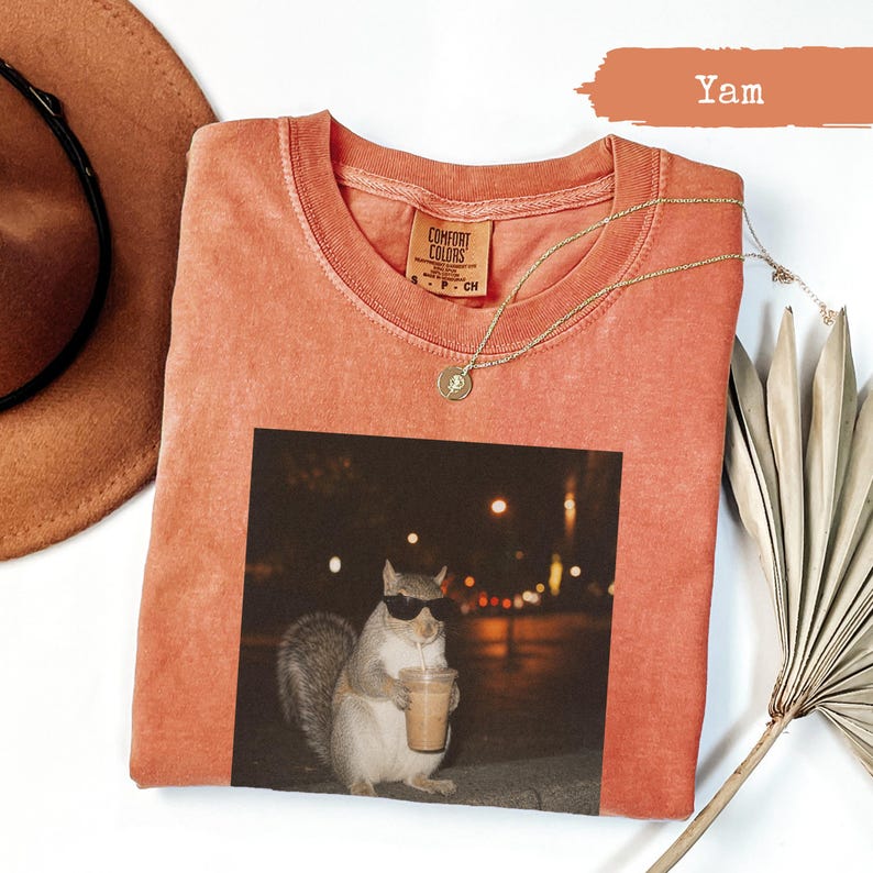 Orange t-shirt with a squirrel wearing sunglasses holding a coffee cup.