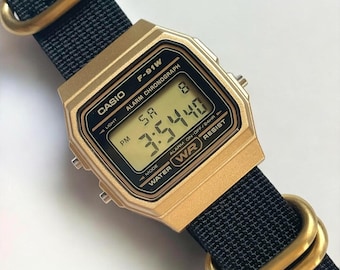 Reloj digital Casio F-91 dorado personalizado: correa de nailon negra con hebilla dorada