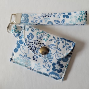 Llavero con tarjetero en miniatura con diseño floral azul sobre fondo blanco
