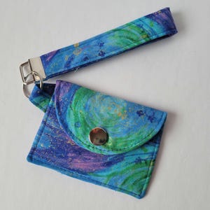 Llavero con tarjetero y estampado en espiral verde, azul y dorado