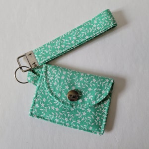 Llavero con tarjetero en miniatura con diseño floral blanco sobre menta