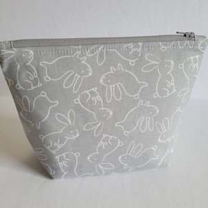 Estuche para lápices con cremallera y fondo plano con diseño de conejitos en gris