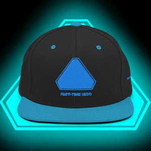 Puede incluir: Gorra de béisbol negra y azul con visera plana. La gorra presenta un diseño de triángulo azul y el texto "PART-TIME HERO" bordado en la parte delantera. La visera y el triángulo son de color azul brillante.