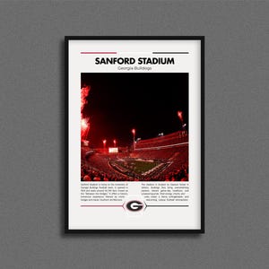 May include: Framed print of Sanford Stadium, home of the Georgia Bulldogs. The image shows the stadium at night with red fireworks and a packed crowd. The text at the top reads "SANFORD STADIUM Georgia Bulldogs."