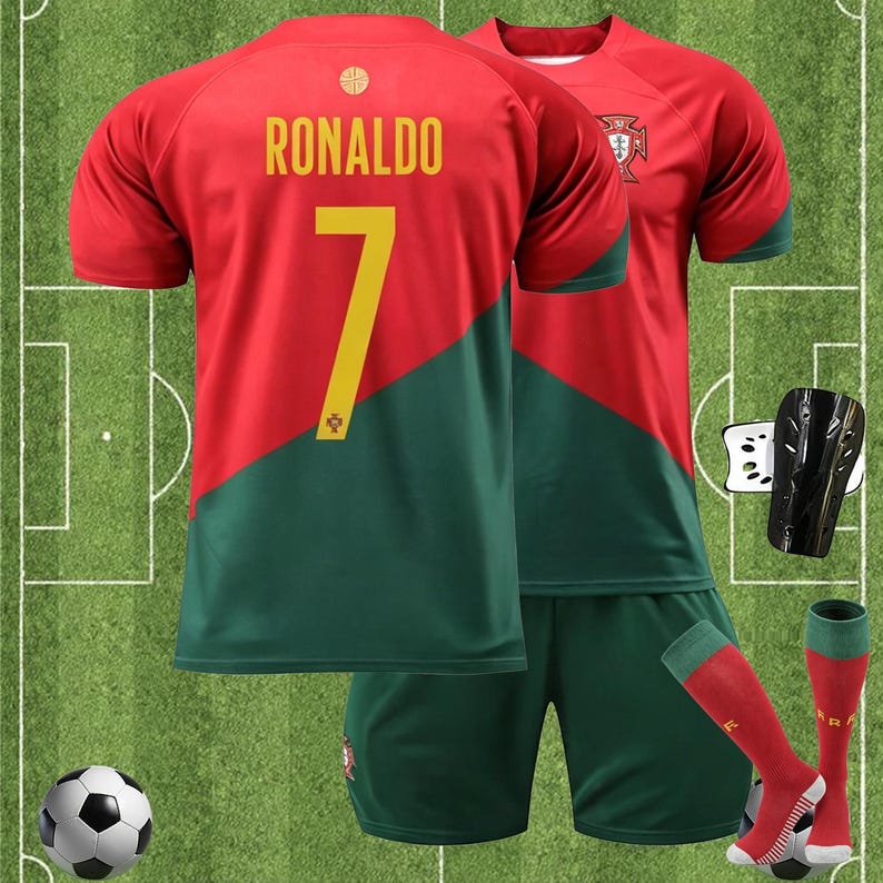 May include: A red and green soccer uniform with the name "RONALDO" and the number "7" on the back. The uniform includes a jersey, shorts, and socks. A soccer ball and shin guards are also included in the image.