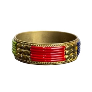 May include: A gold-toned metal bangle bracelet with colorful enamel accents. The bracelet features sections of red, green, and blue enamel, along with gold-colored geometric embellishments. A stylish piece of jewelry.