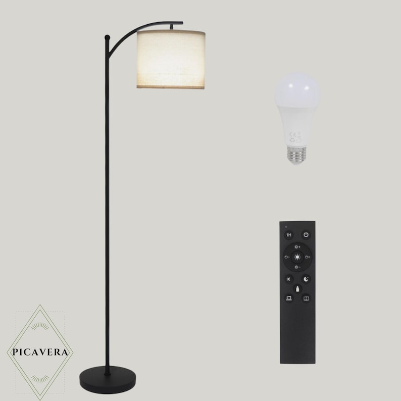 May include: A black floor lamp with a beige lampshade, a remote control, and a light bulb. The lamp has a curved arm and a round base. The remote control has several buttons. The light bulb is white.