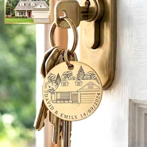 Può includere: Un portachiavi rotondo in metallo color oro con un'illustrazione incisa al laser di una casa e alberi. Il testo "DAVID & EMILY" e la data "14/09/2024" sono incisi lungo il bordo inferiore. Il portachiavi pende da una chiave in una serratura.