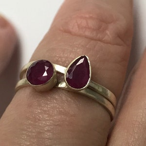 Peut inclure: Une bague en argent avec deux pierres précieuses rouges. L'une est ronde et l'autre en forme de larme.