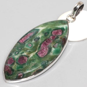 May include: A silver pendant featuring a green and pink gemstone with a unique marbled pattern. The gemstone is set in a silver bezel and has a teardrop shape.