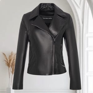 May include: A black leather jacket with a classic asymmetrical zipper closure. The jacket features a notched collar, long sleeves, and a tailored fit. The label reads "True Italian Leather".