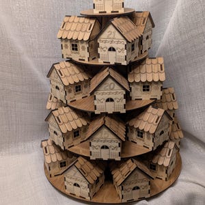 May include: A tiered wooden advent calendar in the shape of a Christmas tree. The natural wood houses are numbered and feature decorative cutouts. The houses are arranged on circular platforms, creating a festive display.