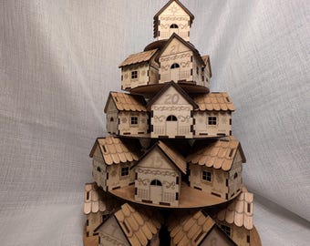 May include: A wooden advent calendar shaped like a tiered village. Each house is laser-cut with intricate details, including doors, windows, and decorative patterns. Numbers are etched on the houses. The calendar is made of light brown wood.